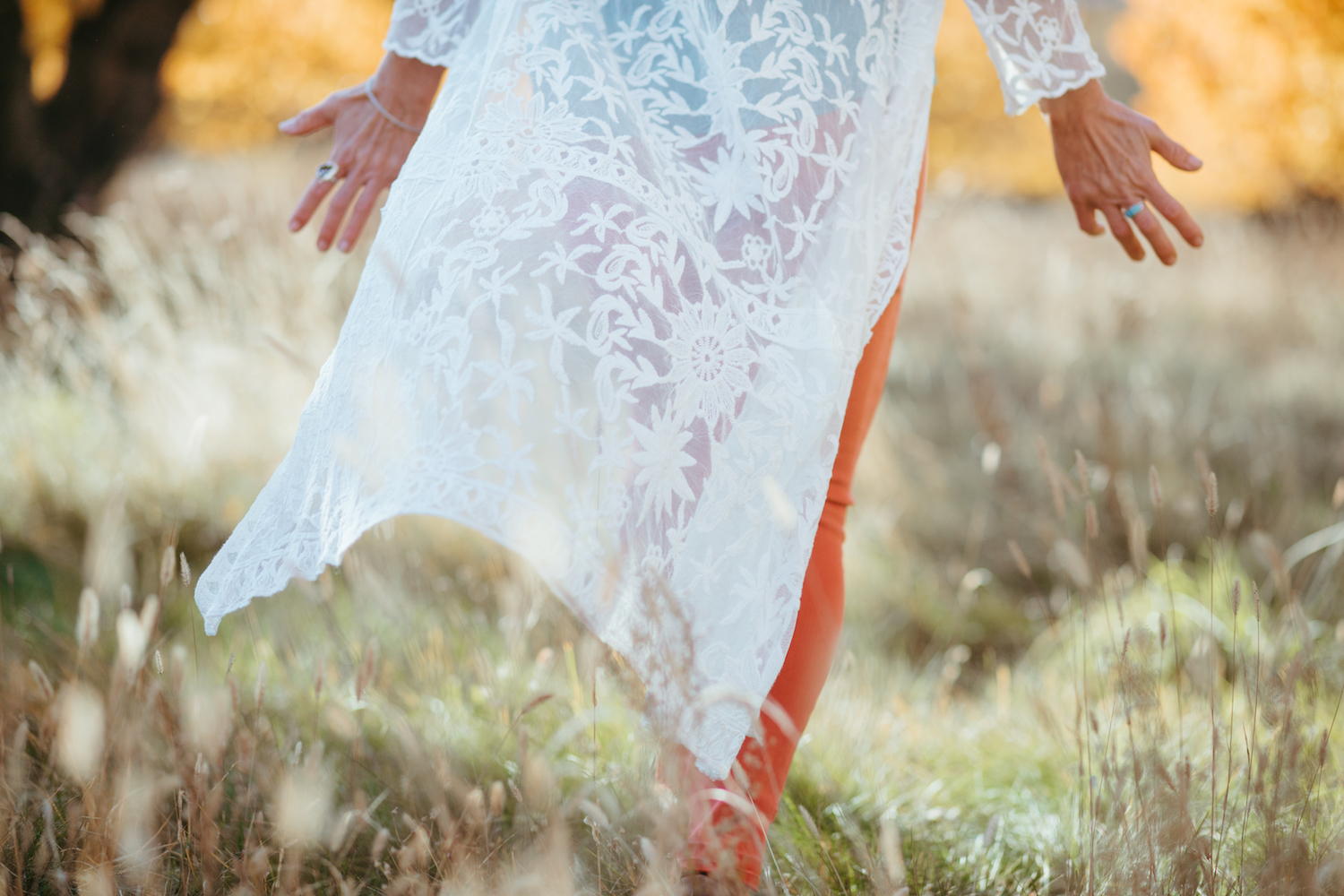 lower body image of woman in white walking through field