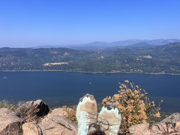 view of sneakered feet on rock cliff
